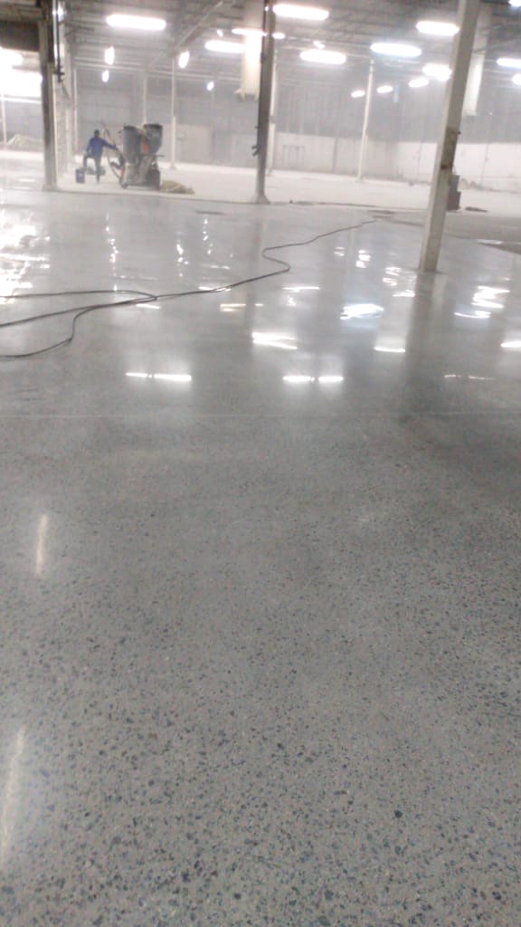Piso de concreto polido em galpão durante a execução da obra