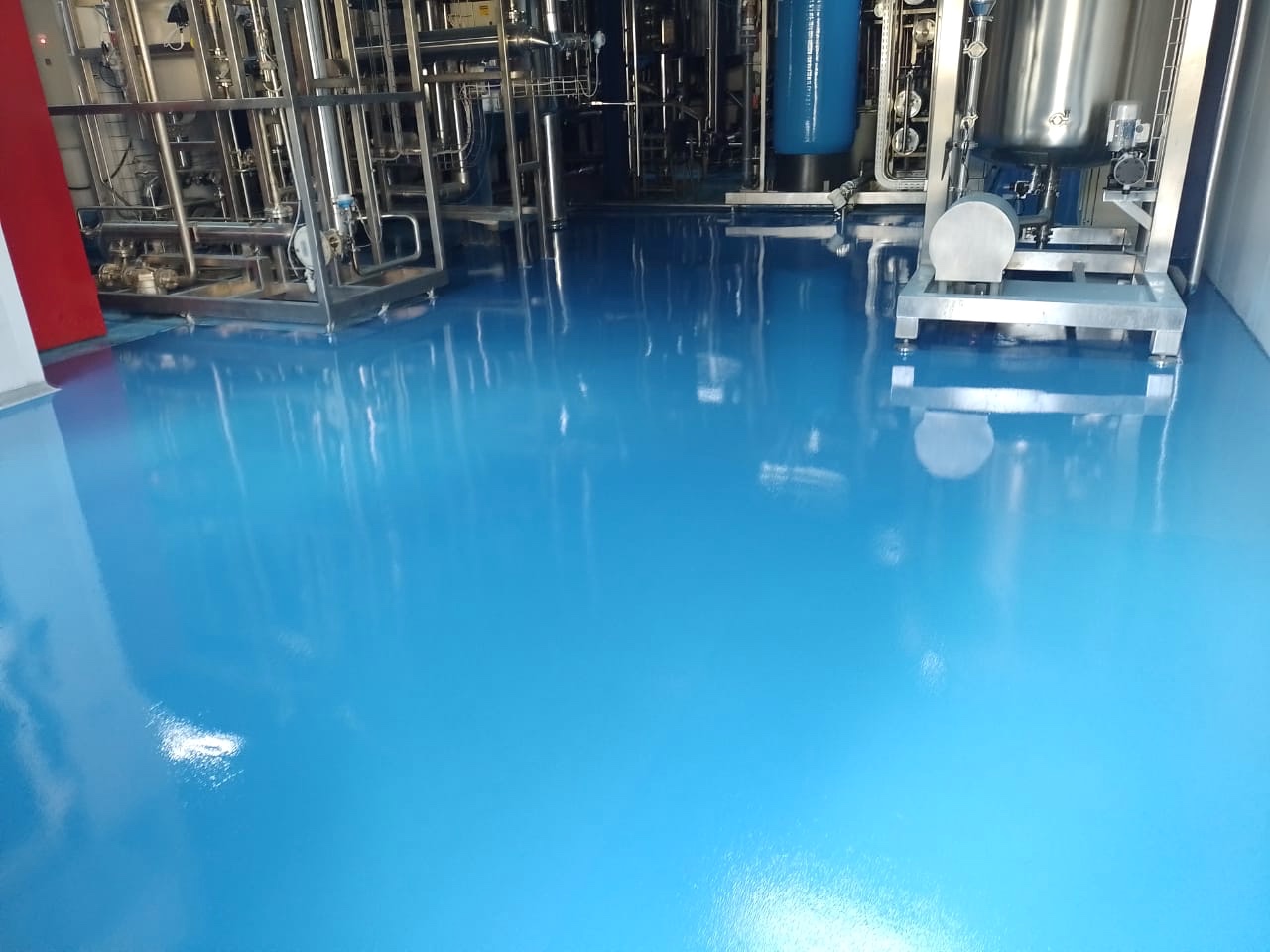Piso industrial azul com equipamentos de aço inoxidável